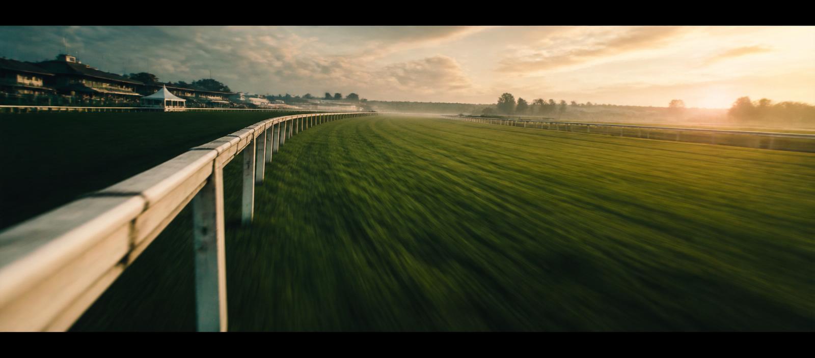 Racecourse finish-line rail perspective at dawn